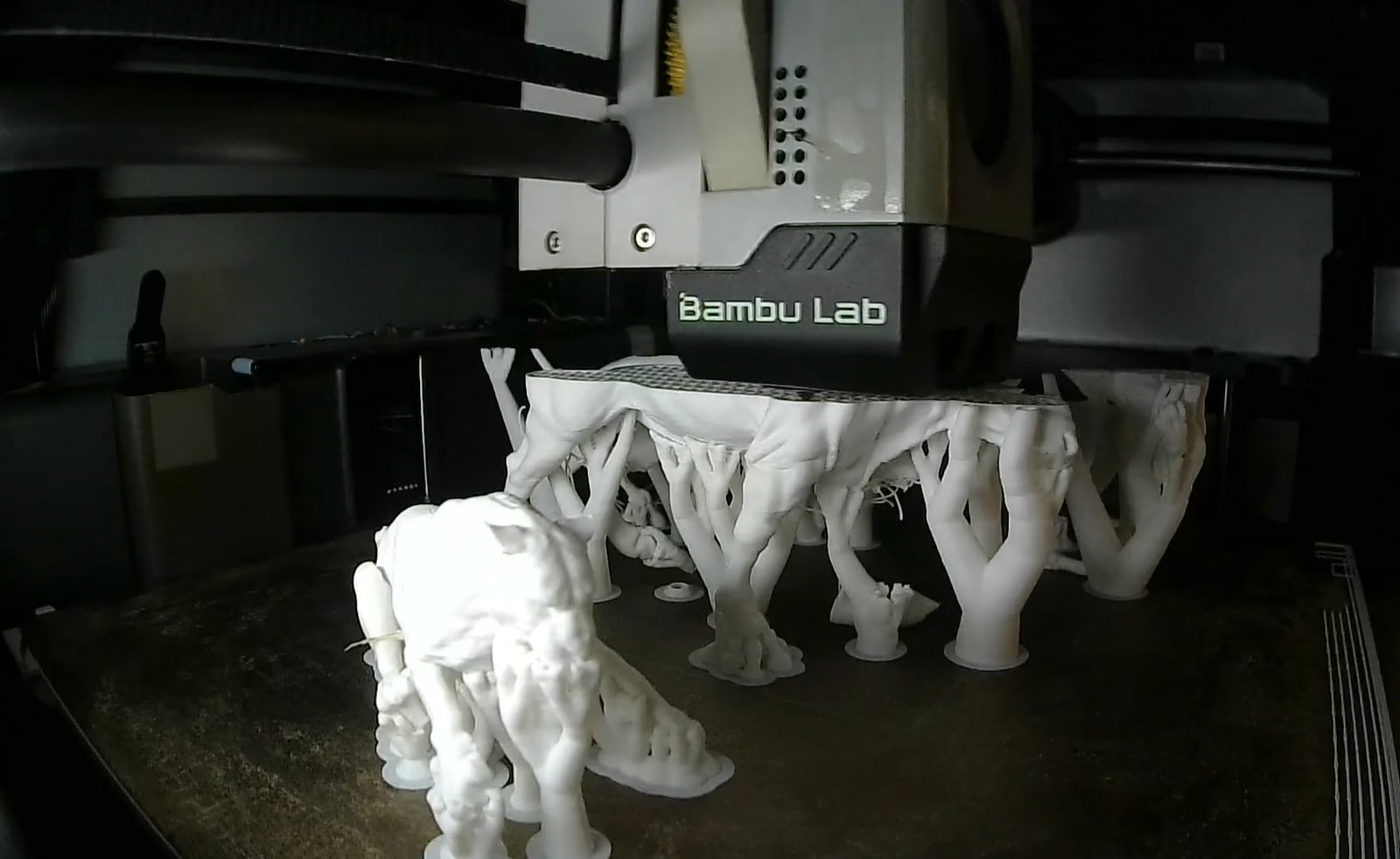Detailed white custom pieces being produced on a 3D printer